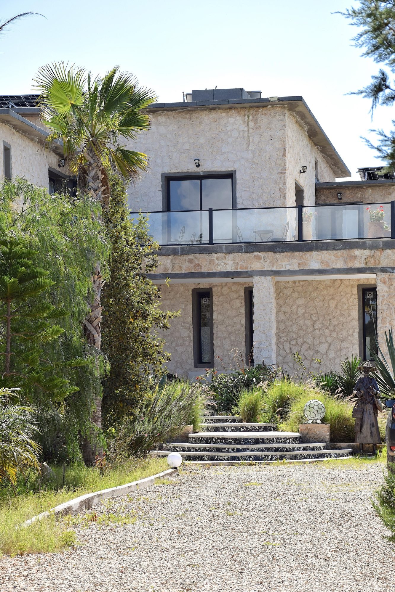 Allée d'entrée de la villa Octagon au milieu des palmiers