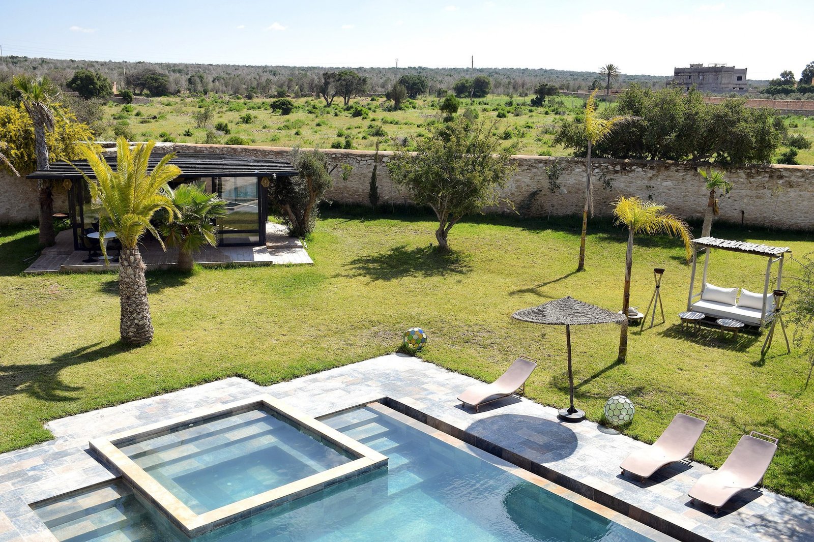 Jardin clos de 5 000 m² avec piscine et palmiers à la villa Octagon