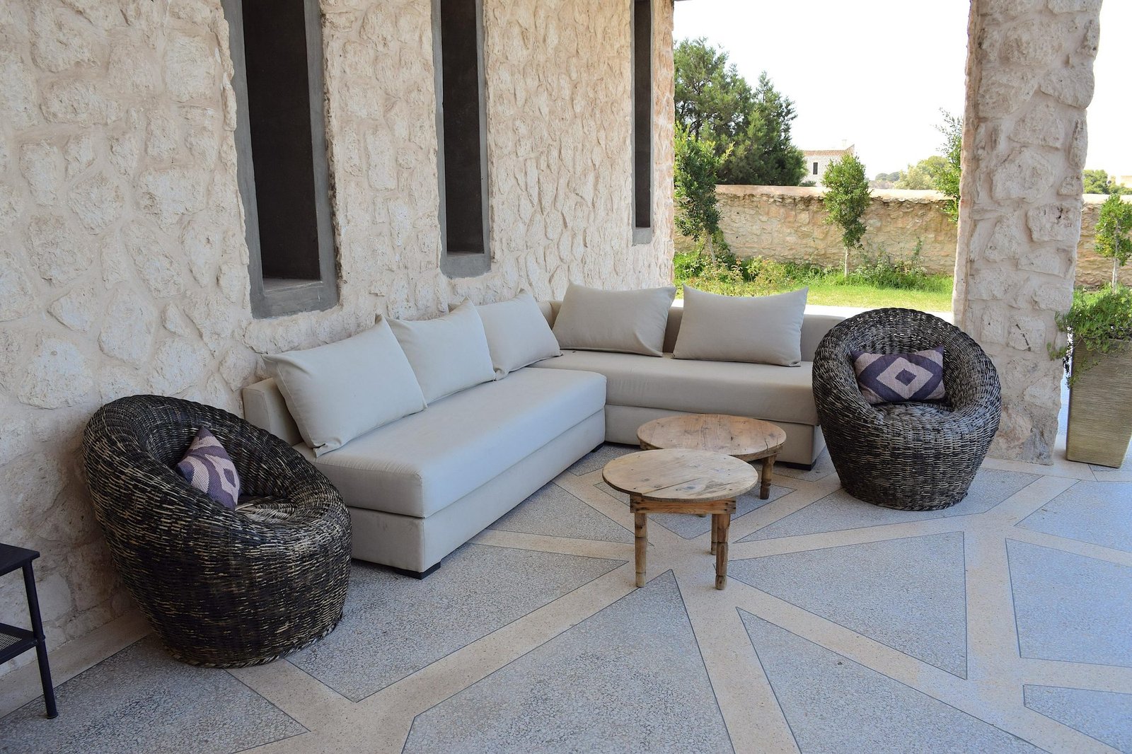 Salon extérieur avec canapé et fauteuils en osier