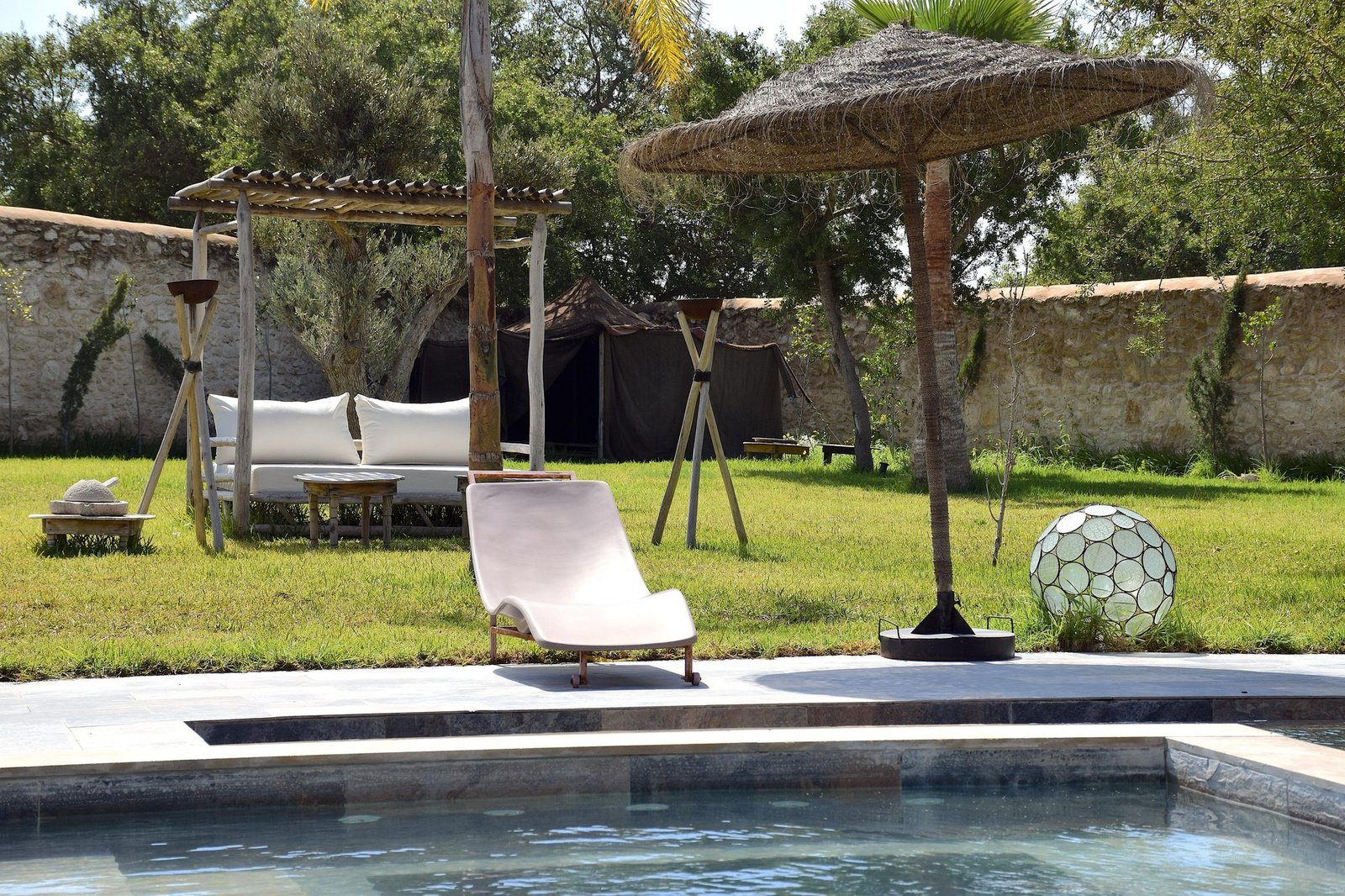 Transats et parasol au bord de la piscine chauffée de la villa Octagon